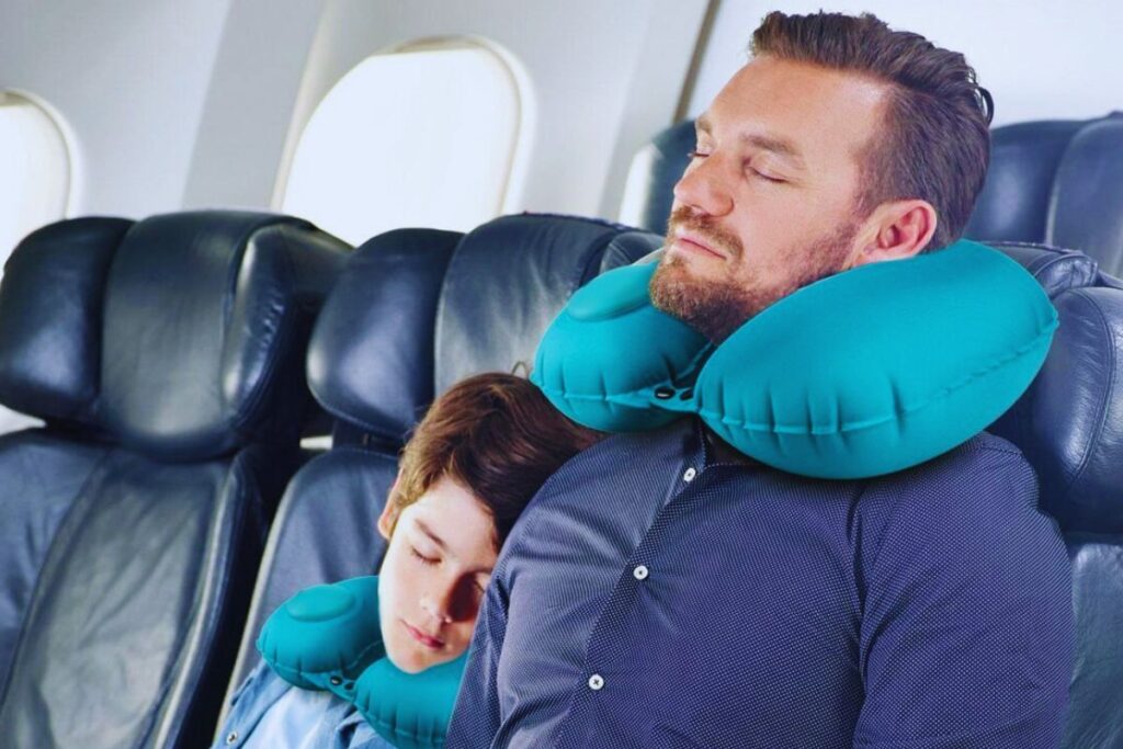 A man and a child wearing travel pillow