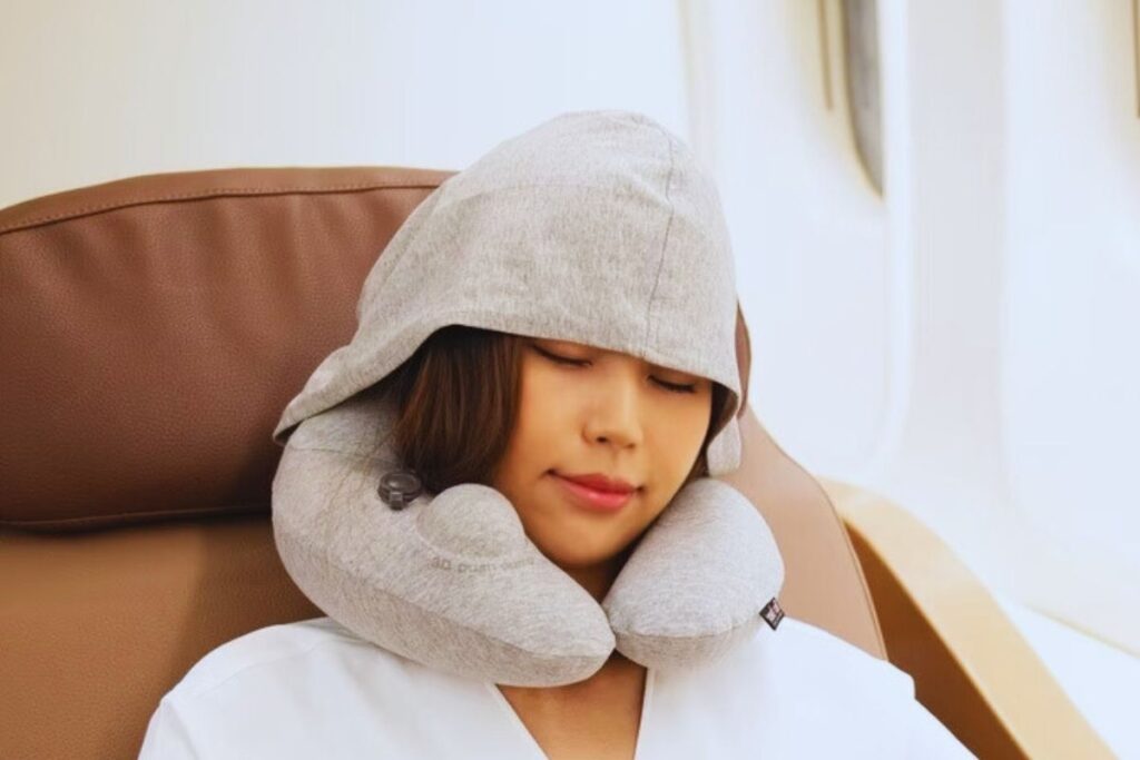 A girl wearing travel pillow inside airplane